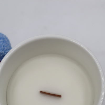 아로마 센세이션은 목제 심지로 하얀 요업 칸델라를 냄새맡았습니다